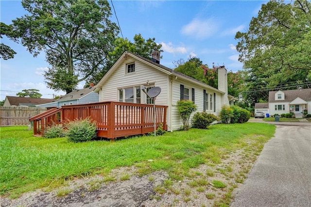 view of side of home featuring a yard and a deck