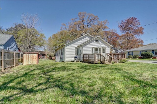 back of house with a lawn and a deck