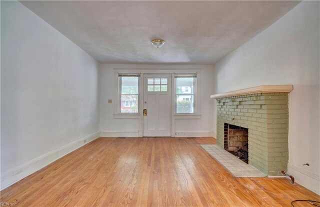 unfurnished living room with light wood-type flooring and a fireplace