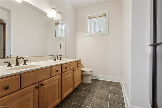 bathroom with tile patterned flooring, dual vanity, and toilet