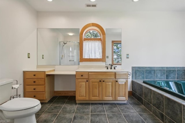 bathroom featuring tiled bath, tile patterned floors, toilet, and vanity