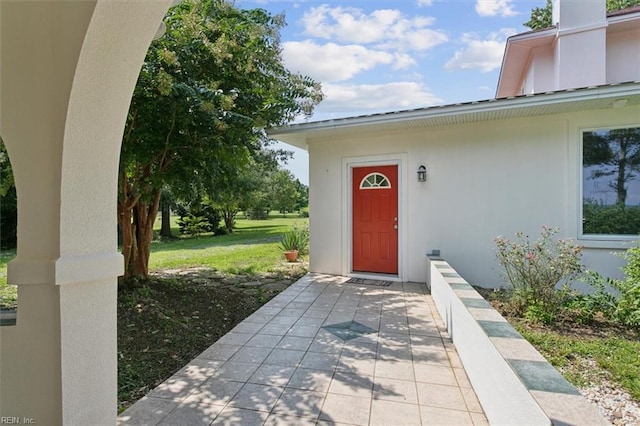 doorway to property with a lawn