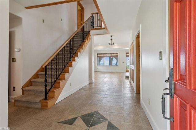 foyer with tile patterned floors, a notable chandelier, and a high ceiling