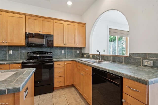 kitchen featuring light tile patterned flooring, backsplash, black appliances, and sink