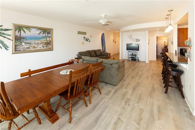 dining area with light wood-type flooring and a ceiling fan