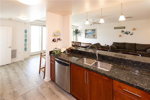 kitchen featuring a sink, visible vents, open floor plan, stainless steel dishwasher, and pendant lighting