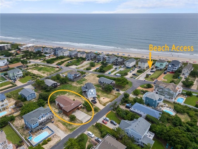 bird's eye view with a water view and a beach view