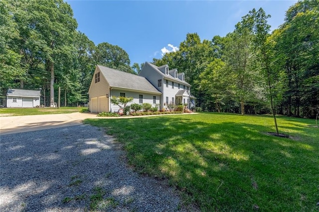 view of front of home with a garage, an outdoor structure, and a front yard