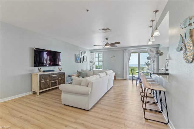 living room featuring ceiling fan and light hardwood / wood-style floors