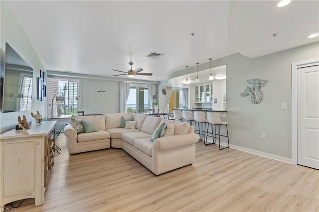 living room featuring ceiling fan and light hardwood / wood-style floors