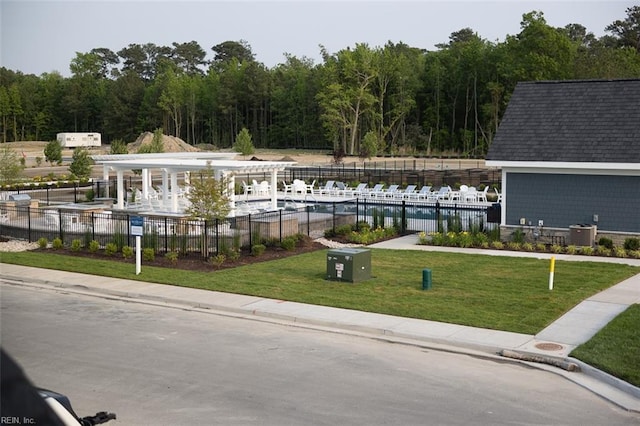 view of home's community with a view of trees, fence, and a yard