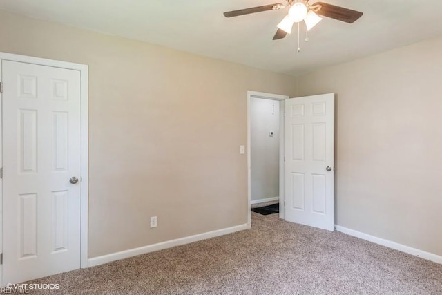 carpeted spare room with ceiling fan