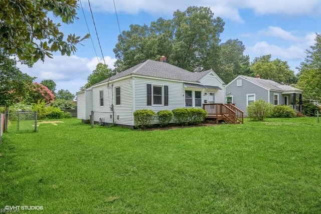 back of property featuring a deck and a lawn