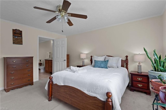 carpeted bedroom with ornamental molding, ceiling fan, and ensuite bath