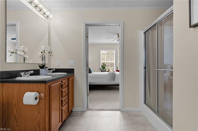 bathroom with a shower with shower door, vanity, crown molding, tile patterned floors, and a textured ceiling