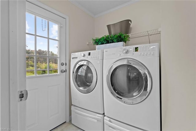 washroom with crown molding, light tile patterned flooring, and washing machine and dryer