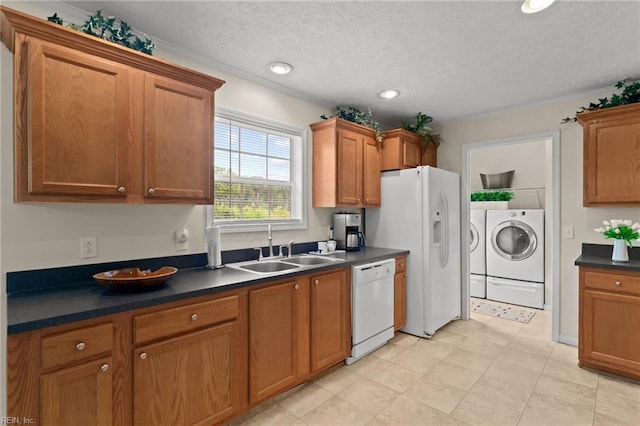 kitchen with sink, white appliances, washing machine and dryer, and a textured ceiling