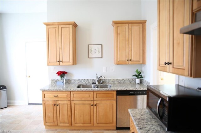 kitchen featuring light tile patterned floors, light stone counters, sink, and stainless steel dishwasher