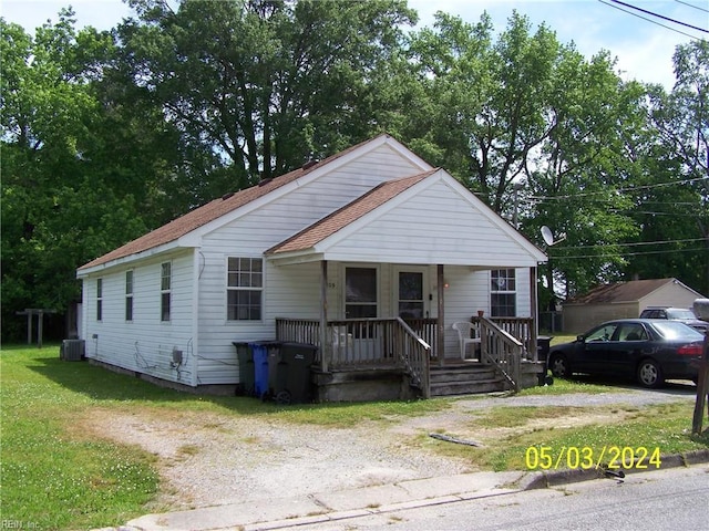 bungalow with a porch and central air condition unit