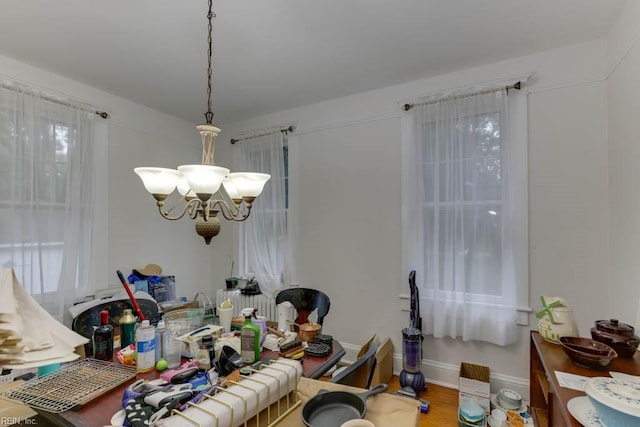 dining space featuring wood-type flooring and a notable chandelier