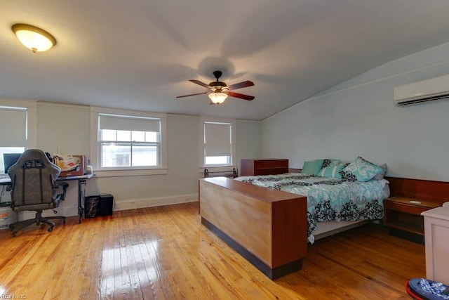 bedroom featuring light hardwood / wood-style floors, vaulted ceiling, a wall mounted air conditioner, and ceiling fan