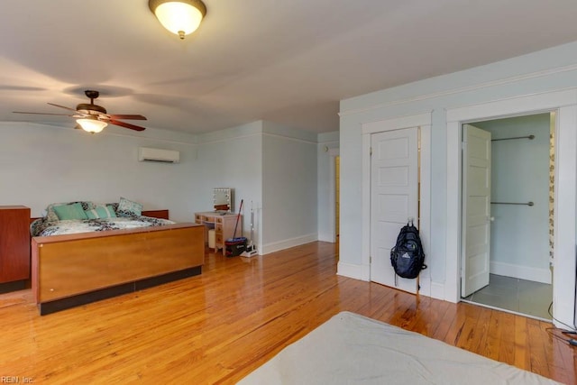 bedroom featuring a wall mounted air conditioner, ceiling fan, and hardwood / wood-style floors