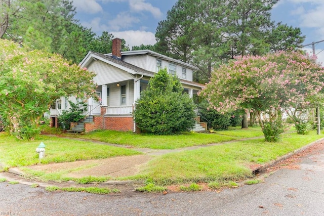 view of side of home with a lawn and covered porch