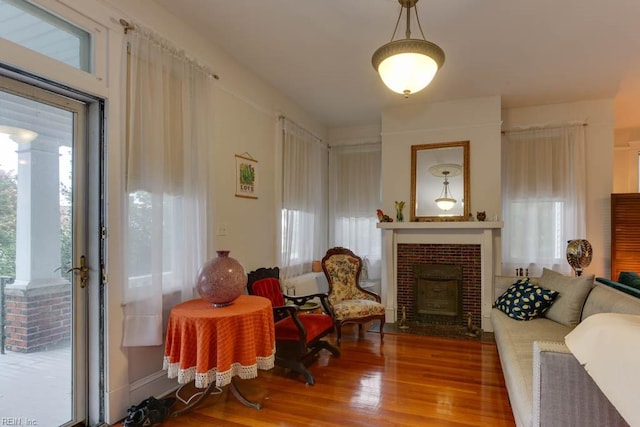 living room featuring a fireplace, hardwood / wood-style flooring, and a healthy amount of sunlight