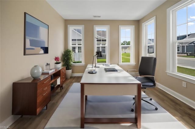 home office with dark wood-style flooring, visible vents, and baseboards