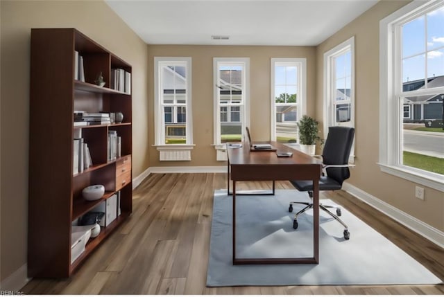 office area featuring dark wood-style floors, visible vents, and baseboards