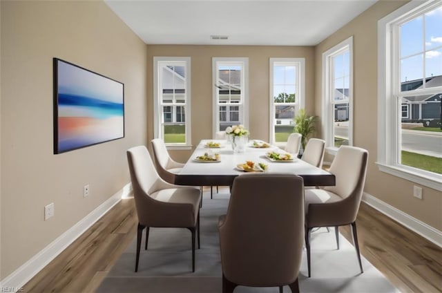 dining area featuring visible vents, dark wood finished floors, and baseboards