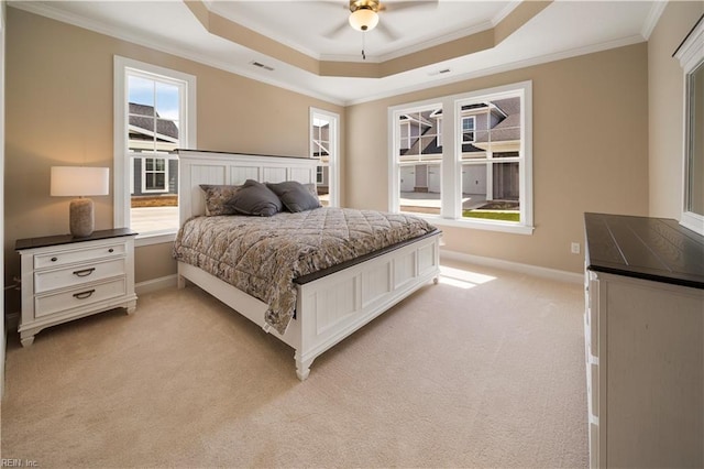 bedroom with light colored carpet, visible vents, baseboards, a tray ceiling, and crown molding