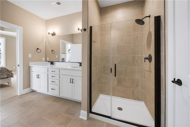 full bath featuring a stall shower, visible vents, a sink, and double vanity