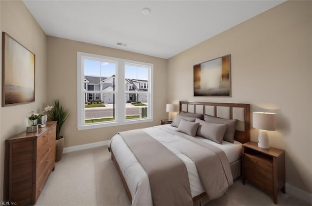 bedroom with light colored carpet, visible vents, and baseboards