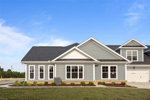 craftsman inspired home featuring a standing seam roof, metal roof, cooling unit, driveway, and a front lawn