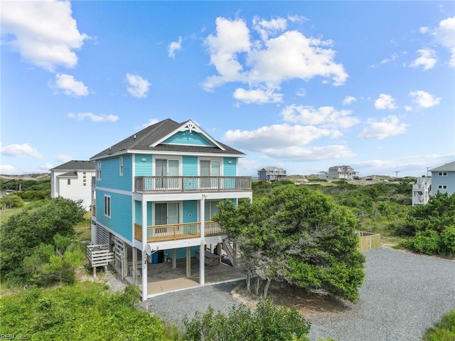 rear view of property with a balcony and a carport