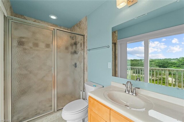 bathroom featuring walk in shower, vanity, and toilet