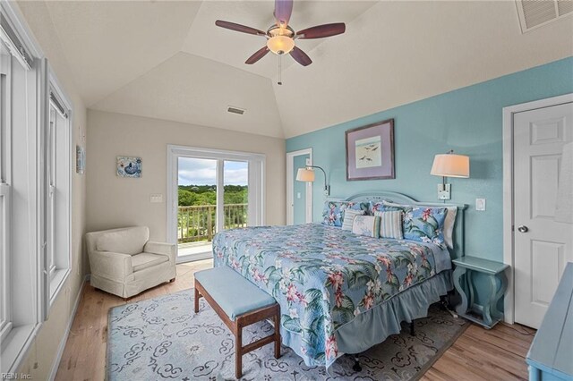 bedroom featuring ceiling fan, access to exterior, light wood-type flooring, and vaulted ceiling