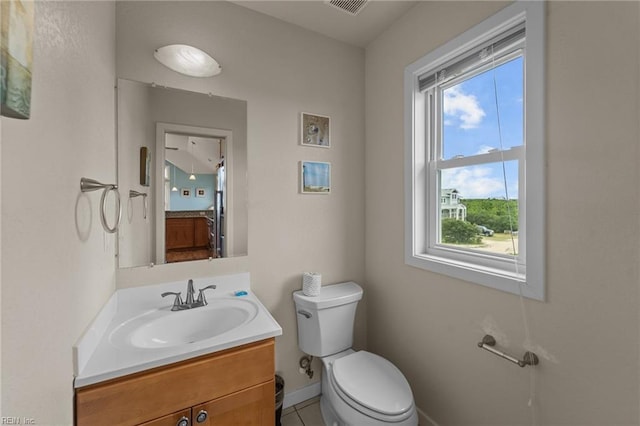 half bathroom featuring toilet, baseboards, visible vents, and vanity