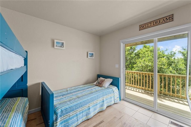 bedroom featuring access to outside, visible vents, and wood finished floors