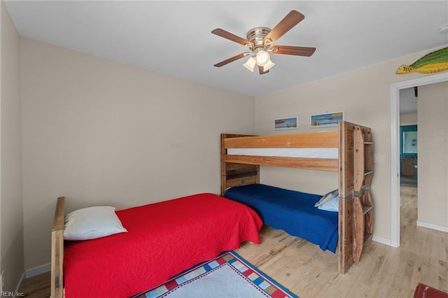 bedroom featuring ceiling fan, wood finished floors, and baseboards