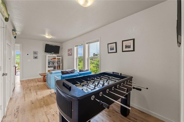 recreation room with light wood finished floors and baseboards