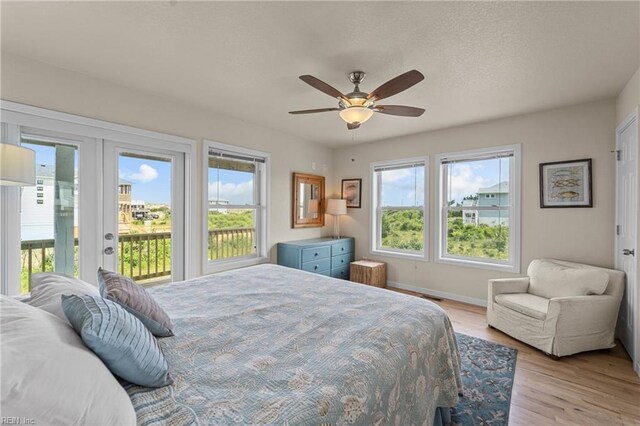 bedroom with access to outside, light hardwood / wood-style flooring, french doors, and ceiling fan