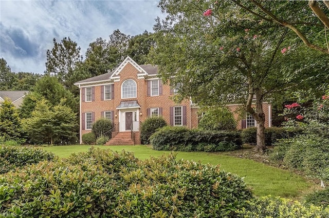 colonial inspired home featuring a front lawn