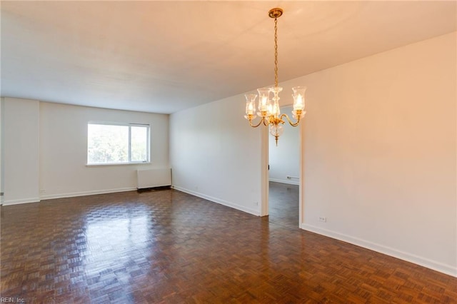 unfurnished room with radiator, dark parquet floors, and a chandelier