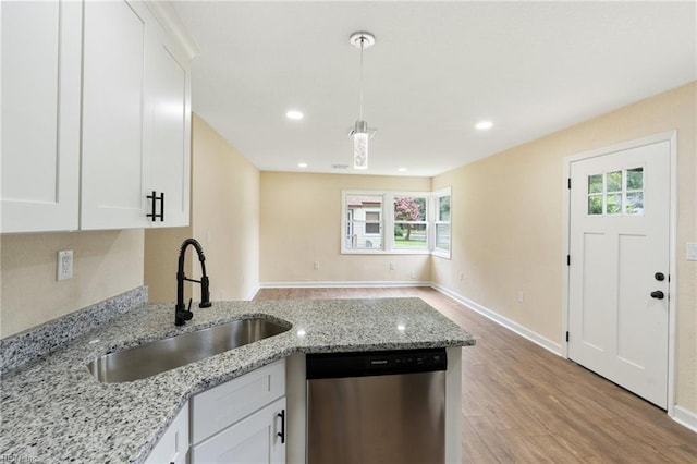 kitchen featuring sink, light hardwood / wood-style floors, stainless steel dishwasher, and a healthy amount of sunlight