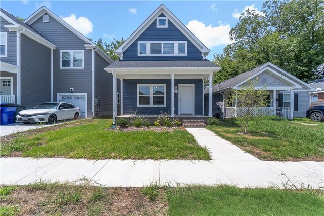 view of front of home featuring a front lawn, a garage, and a porch