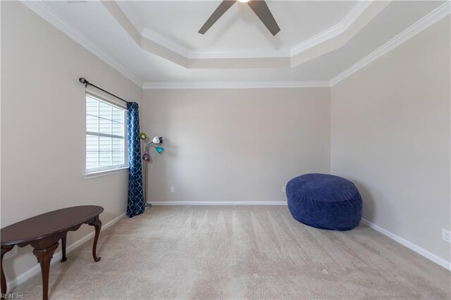 living area featuring light carpet, a tray ceiling, ceiling fan, and crown molding