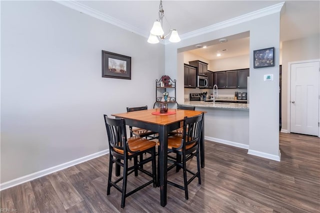 dining space with an inviting chandelier, sink, dark hardwood / wood-style floors, and crown molding