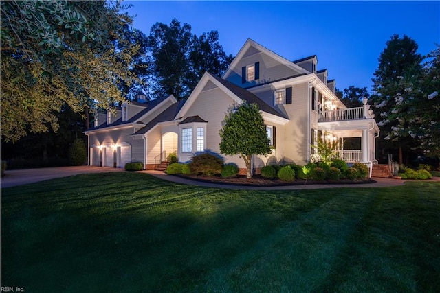 view of front of home featuring a garage, a balcony, and a yard